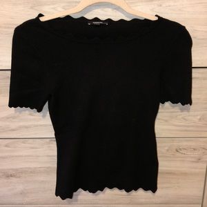 Fitted black top with scalloped detail